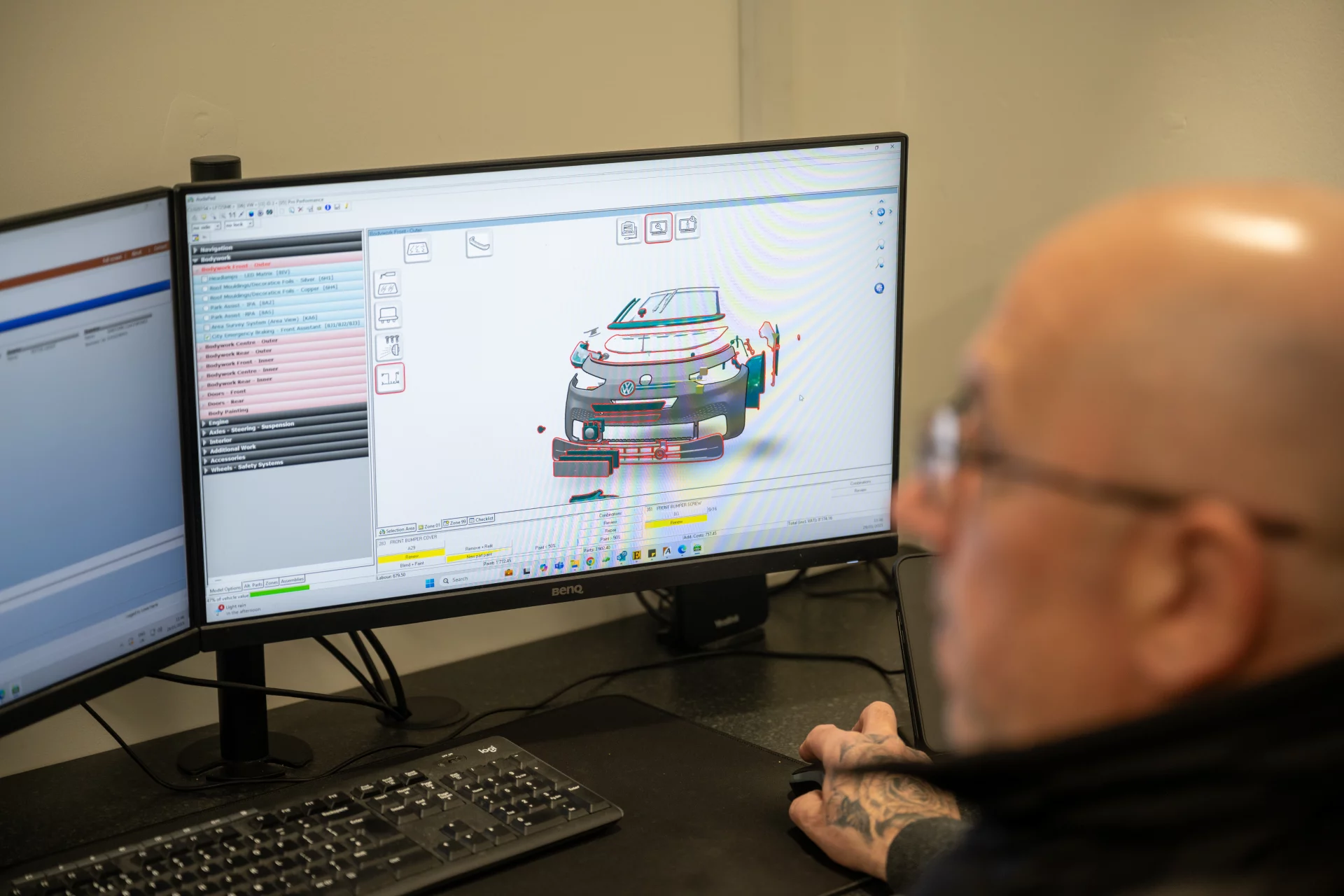 An experienced estimator at Sandown Coachworks using professional car repair estimation software on a dual-monitor setup to assess damage and create an accurate quote.