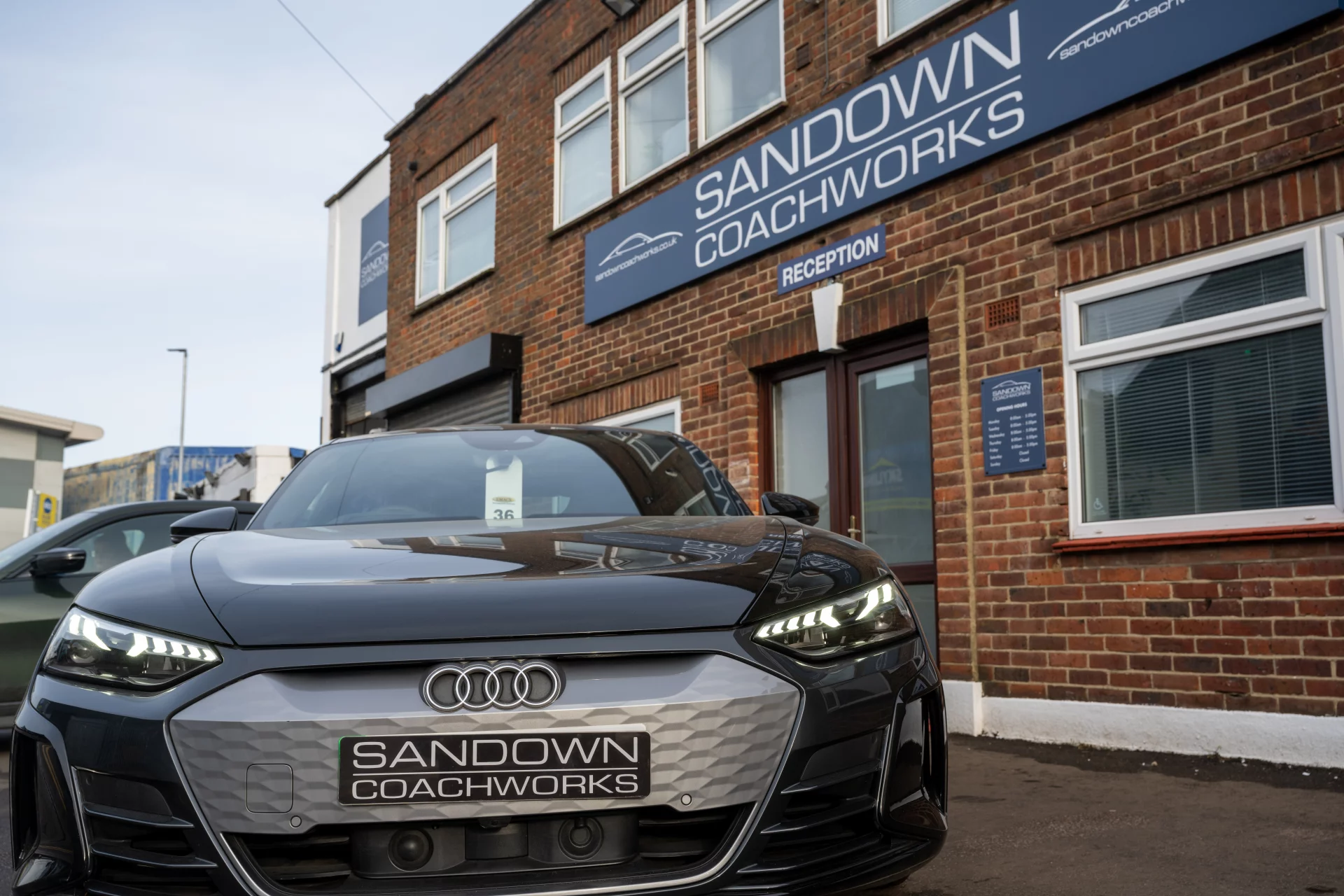 Front view of a black Audi e-tron GT at Sandown Coachworks reception, highlighting prestige electric vehicle repair expertise in Surrey.