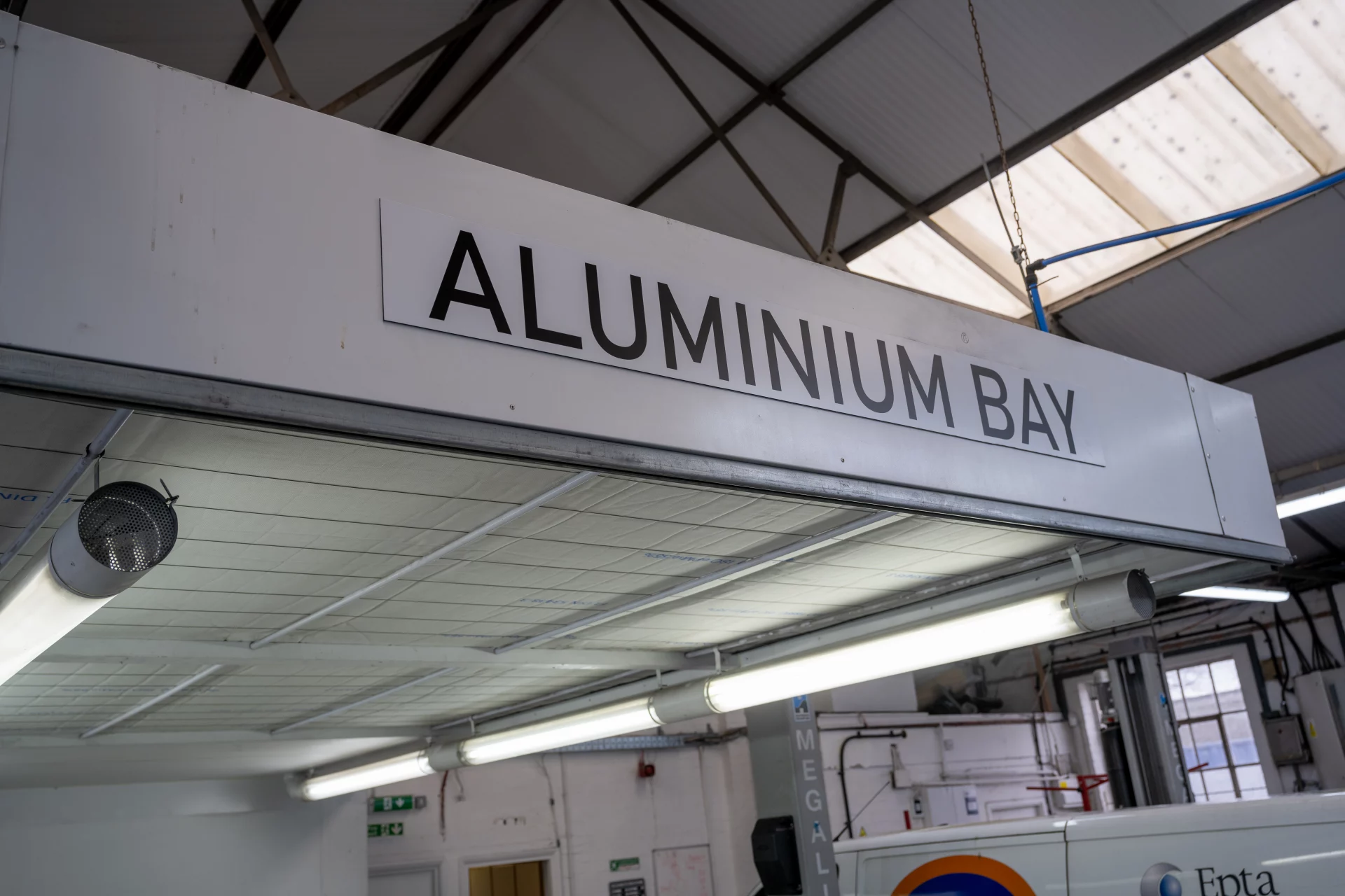 Close-up of the dedicated Aluminium Bay signage at Sandown Coachworks, an Audi and manufacturer-approved structural repair facility.