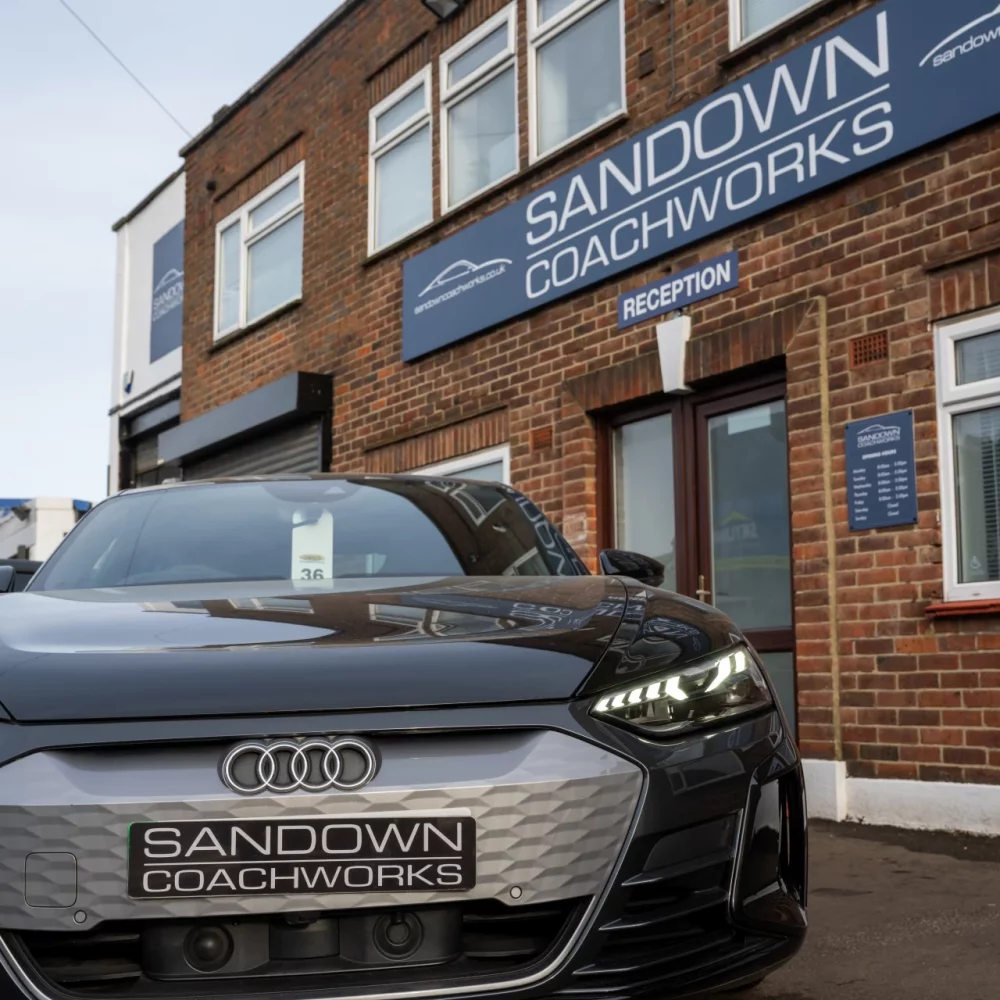 Front view of a black Audi e-tron GT at Sandown Coachworks reception, highlighting prestige electric vehicle repair expertise in Surrey.
