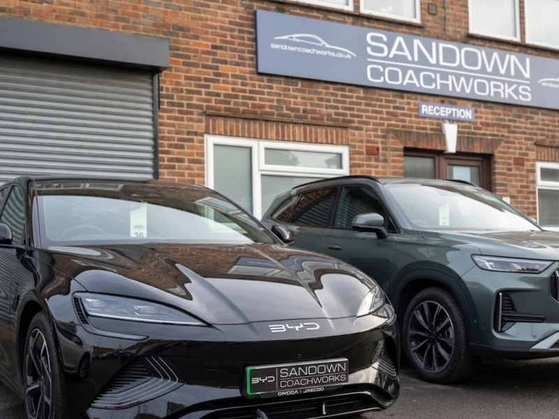 Interior view of the prestigious Sandown Coachworks reception, displaying official approval signage and digital health reports for new-to-the-UK electric vehicle brands like BYD and Jaecoo.