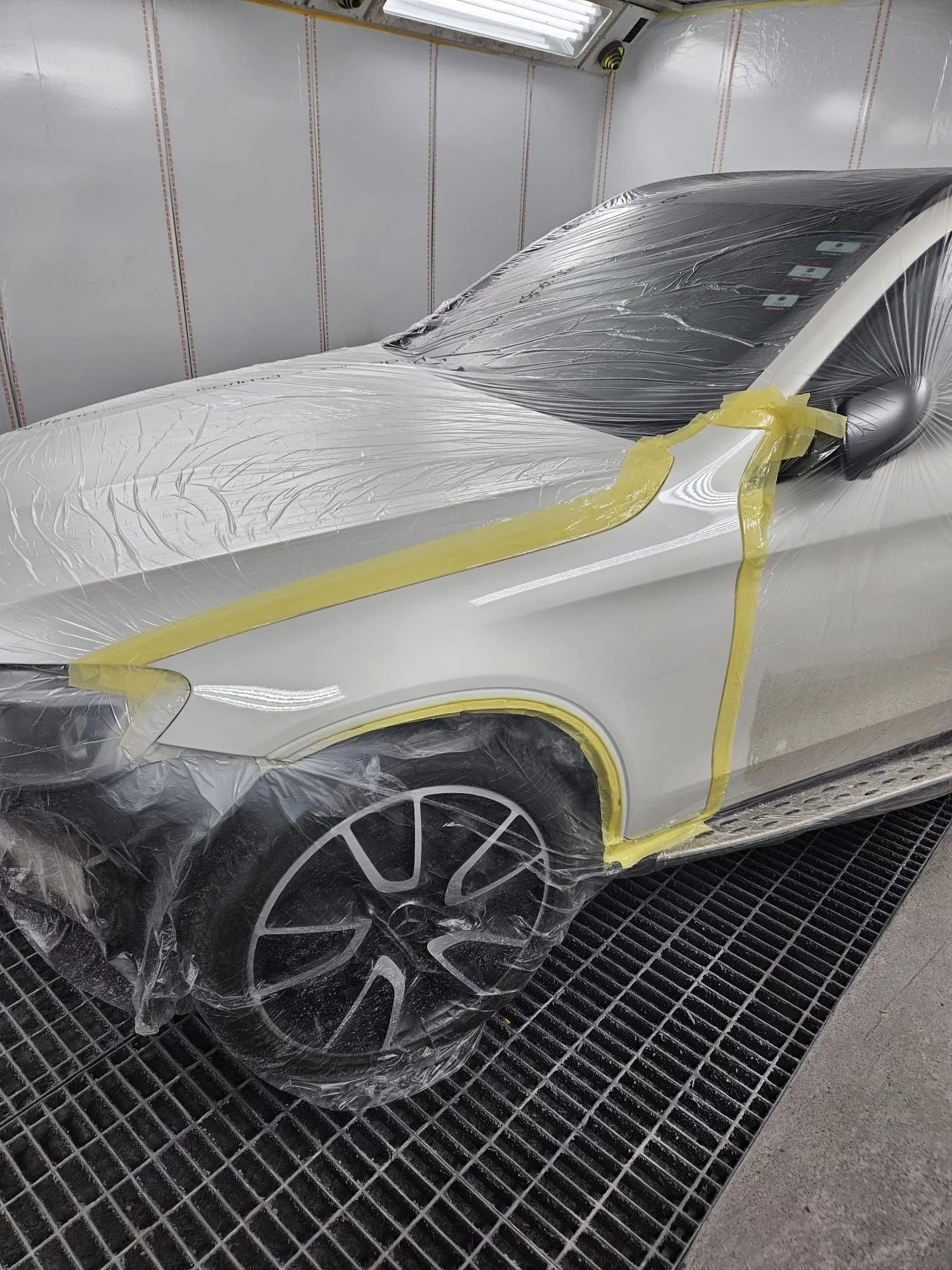 The finished result of a prestige vehicle repair at Sandown Coachworks, showing a flawless factory-standard paint finish and meticulous masking in the spray booth.