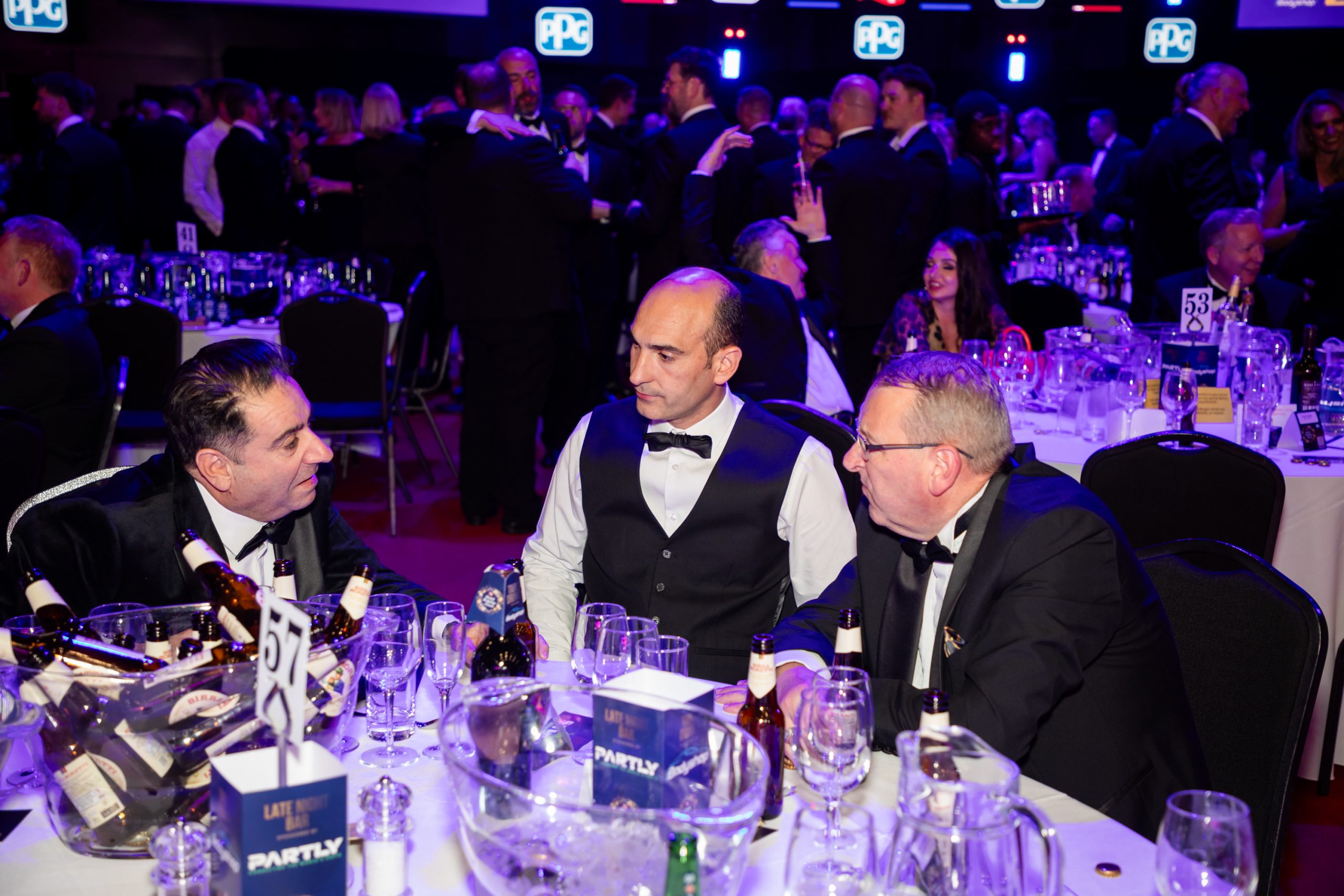 The Sandown Coachworks team networking and discussing industry innovations during the ABP awards dinner in a formal event setting.