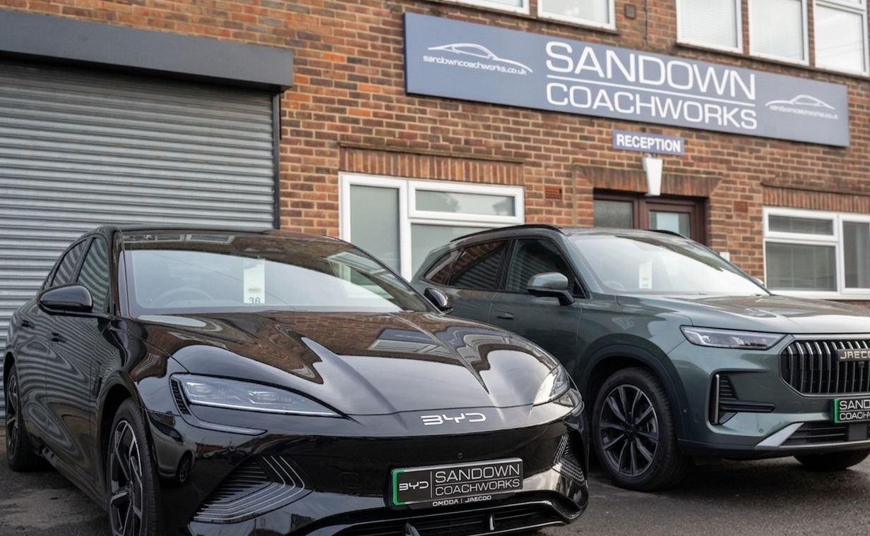 Interior view of the prestigious Sandown Coachworks reception, displaying official approval signage and digital health reports for new-to-the-UK electric vehicle brands like BYD and Jaecoo.